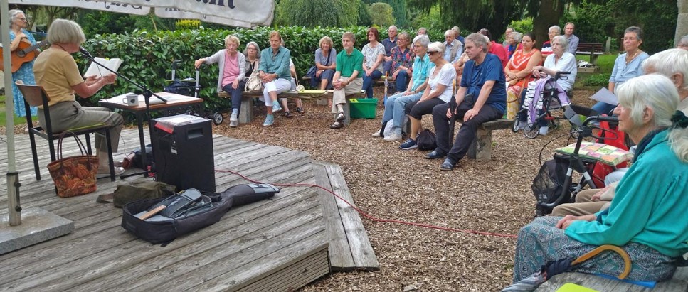 Lauenburg, Friedhof, Himmelsgarten, Kerstin Ruff (Gitarre) und Margot Wegner (Buch) vor Publikum